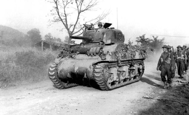 Sherman de la 26ª Armoured Brigade junto a infantería de los Guardias Galeses avanzando hacia las posiciones alemanas en la Línea Gótica. Noviembre de 1944