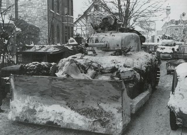 Sherman M4A1 bulldozer del 743º Tank Battalion despejando  de nieve la calzada en la ciudad belga de Malmedy. Enero de 1945
