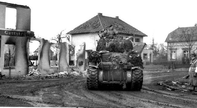Sherman Firefly de la 7ª Armoured Division avanzando por las ruinas de la localidad alemana de Borken. 30 de marzo de 1945
