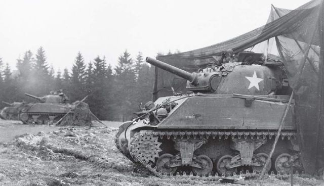 Tres M4 105 Sherman de la 3ª Armored Division equipados con cañones de 105 mm abriendo fuego sobre la posiciones alemanas en las Ardenas. 29 de los Sherman de esta unidad fueron rearmados con los Howitzer de 105 mm