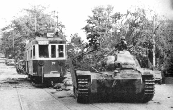 StuG III de la 9ª SS Hohenstaufen pasa junto a un tranvía en las calles de Oosterbeek, durante el avance aliado hacia el bajo Rhin. Septiembre de 1944