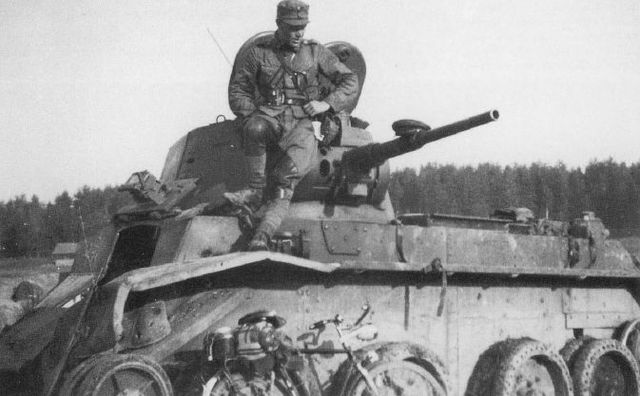 Ciclista finlandés posando junto a un tanque BT-7 puesto fuera de combate